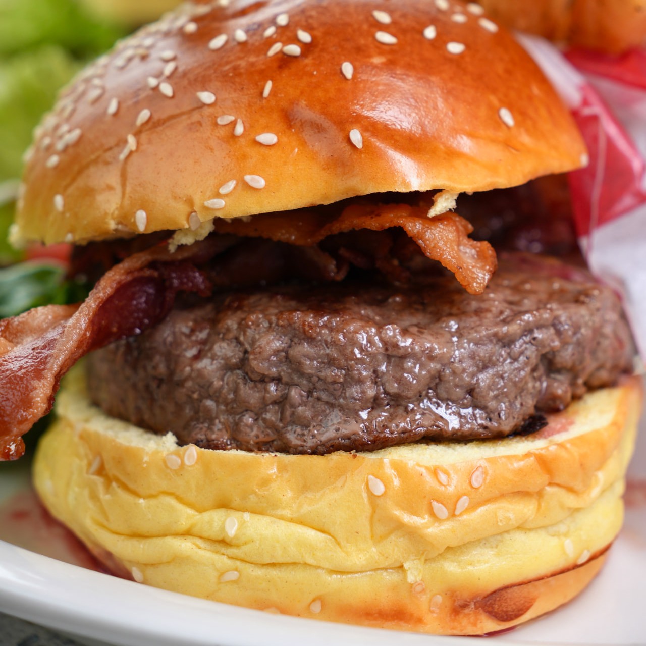 Bacon cheeseburger on a brioche bun with fries
